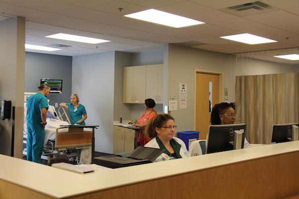 Two informatics nurses working at computers at a nurses desk.