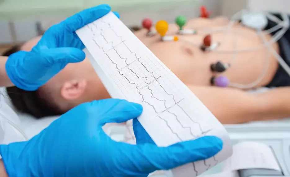 EKG Technician reads out graph with a patient